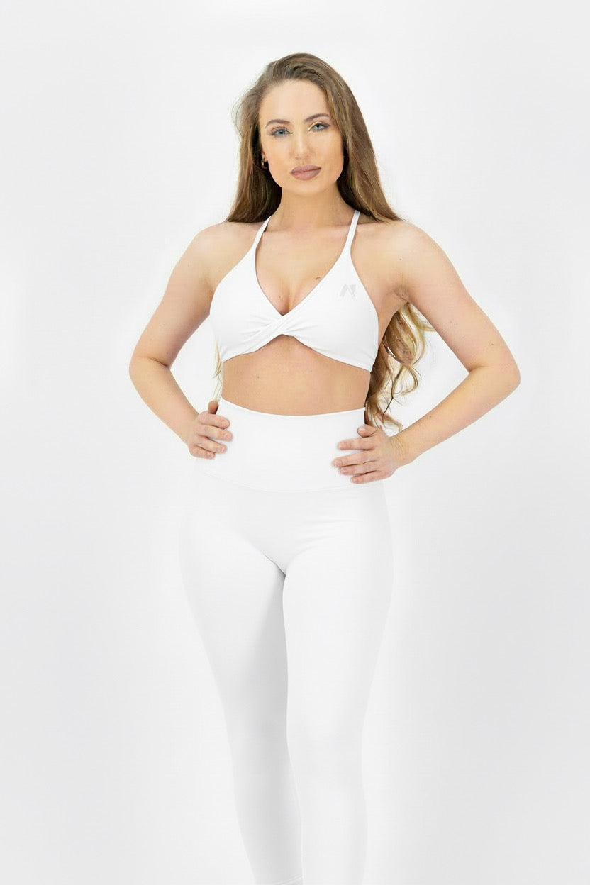 Woman wearing a white bikini top and pants on a white background
